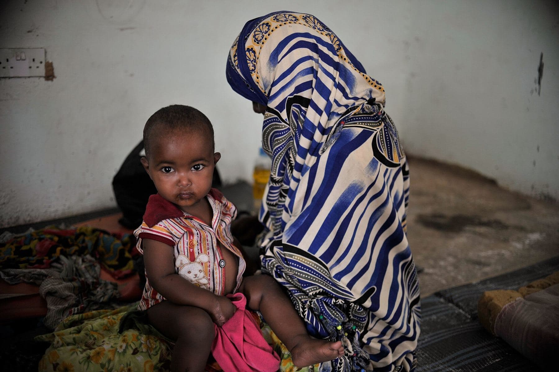 A mother sitting with her young child at a community clinic