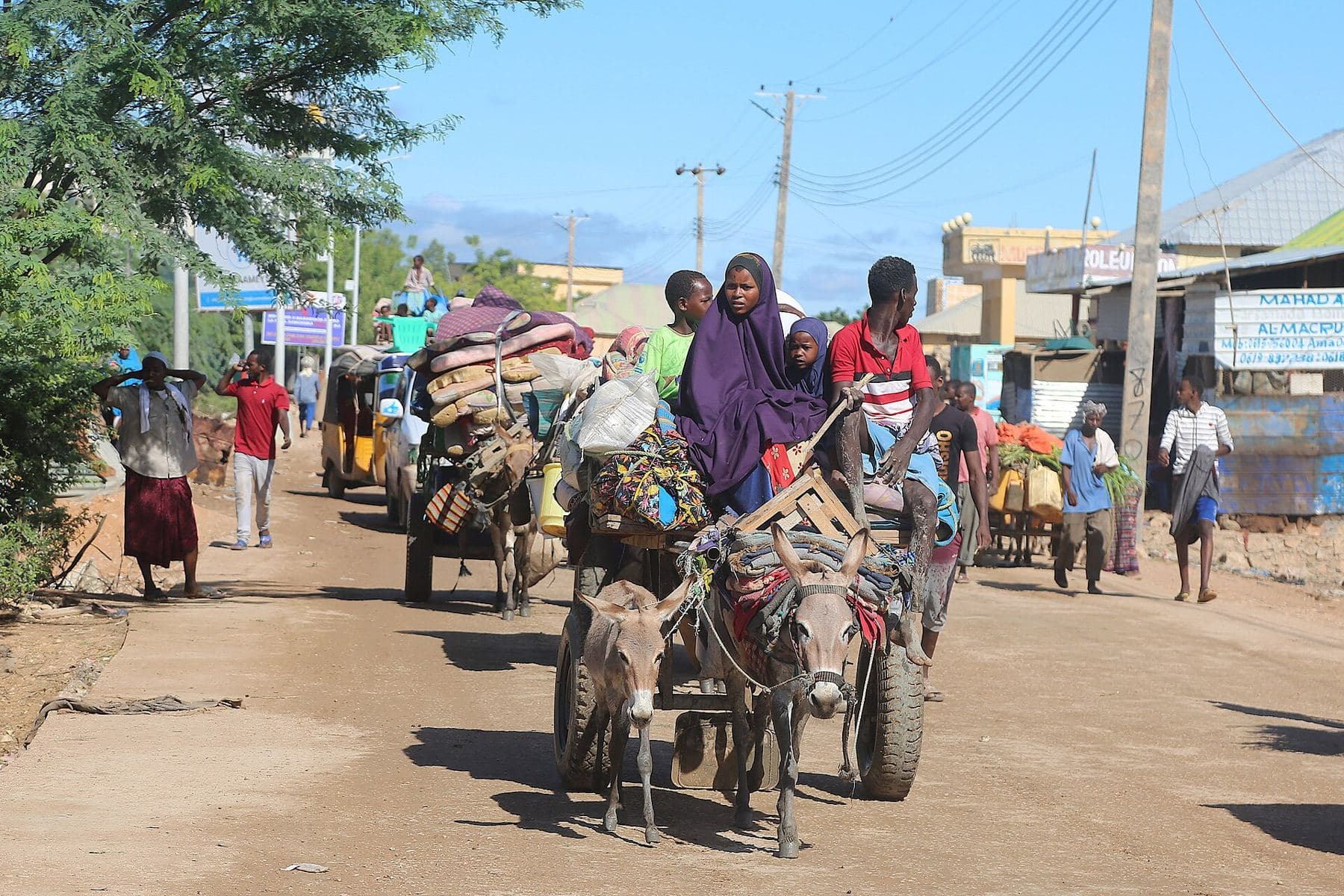 Families with donkey carts carrying their belongings away from flooded homes